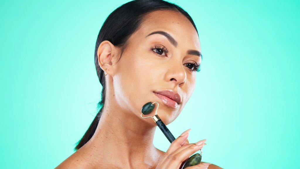 woman using jade roller for jawline