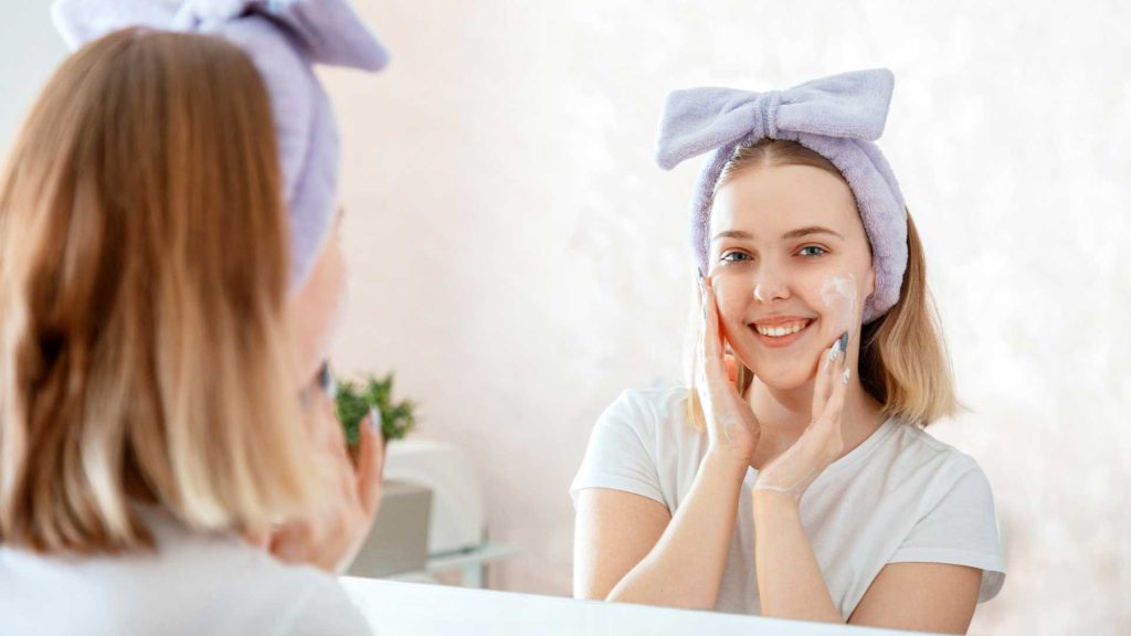 teenager cleansing her face